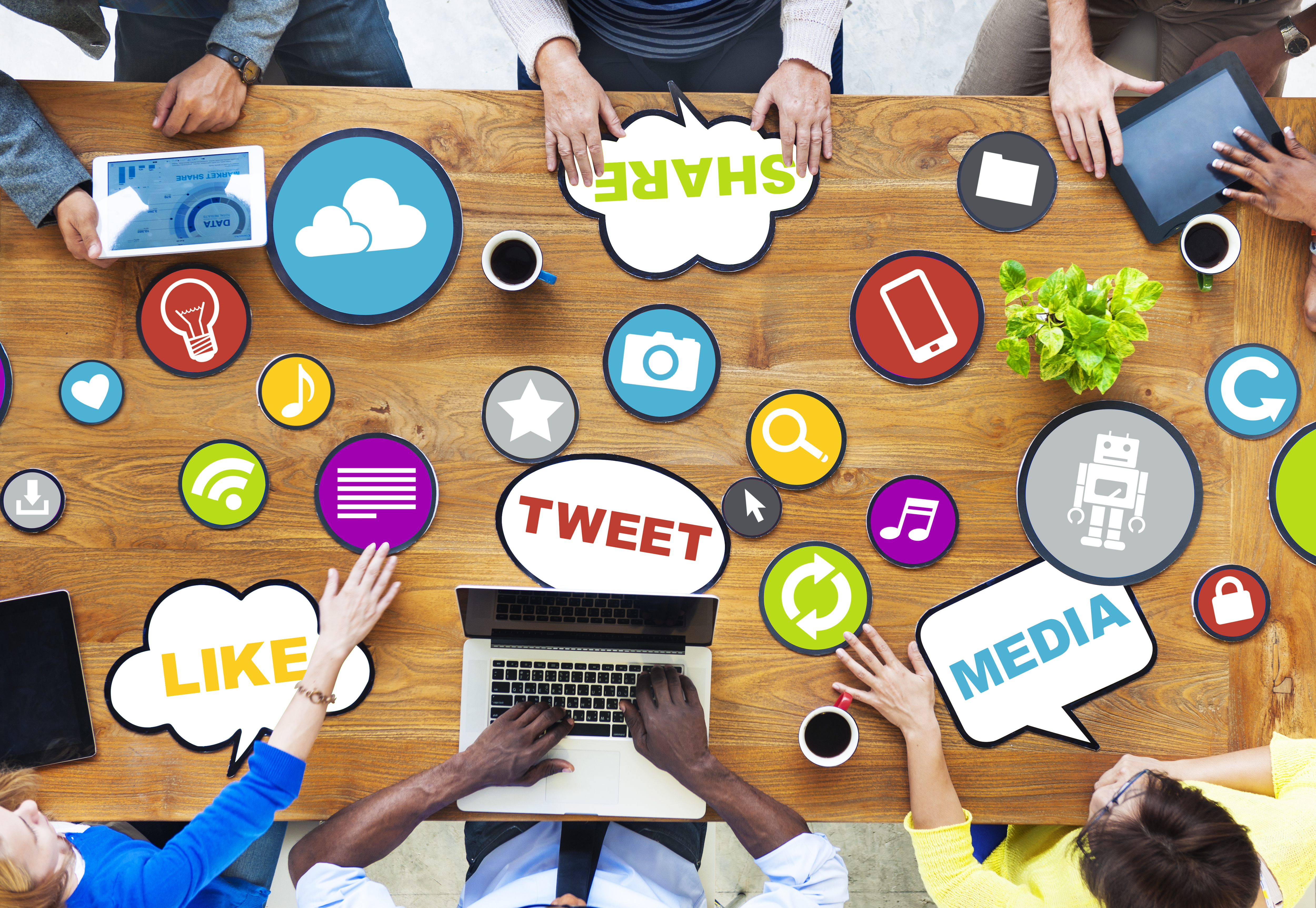 people sit around the table, 
            various social media logos are on the table
